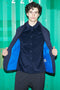 Young man wearing a Reed Shirt Navy Corduroy, opening a jacket to reveal the shirt, standing in front of a green container background.